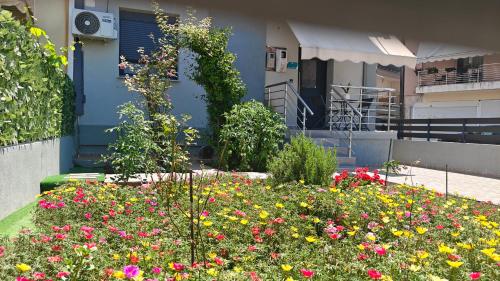 a garden with flowers in front of a house at Black Eagle Apartment in Drama