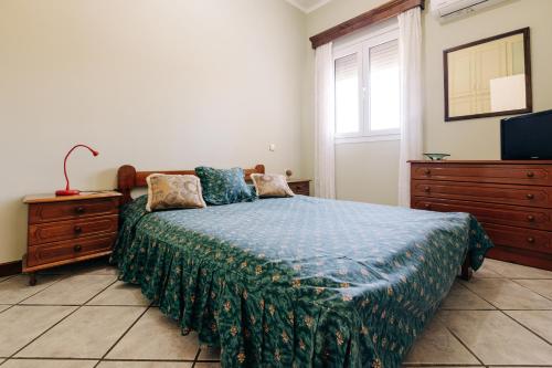 a bedroom with a bed and a dresser and a television at Limnia View in LimiÃ¡