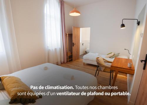 a room with a bed and a desk and a table at Hotellerie de l'Abbaye du Désert in Bellegarde