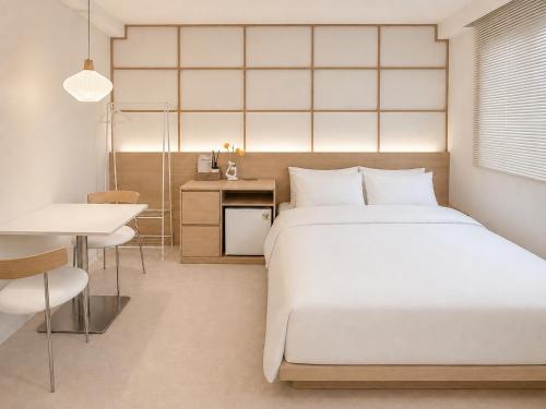 a bedroom with a bed and a table and a desk at 윤스테이 행궁 호텔-Yoonstay Haenggung in Suwon