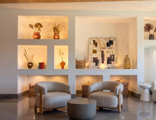 a living room with two chairs and a table at Hotel Maritur - Adults Only by Pierre & Vacances in Albufeira