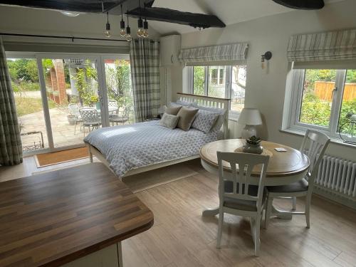 a bedroom with a bed and a table and chairs at Lavender Lodge in Briston