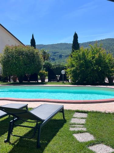 a swimming pool with a table and a chair next to it at RelaxHomeHoliday in Panicale