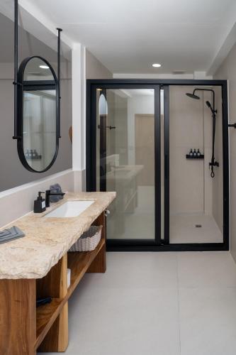 a bathroom with a shower with a sink and a mirror at Aqueduct resort in Ko Tao