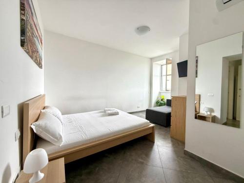a white room with a bed and a mirror at Suite Home in Naples