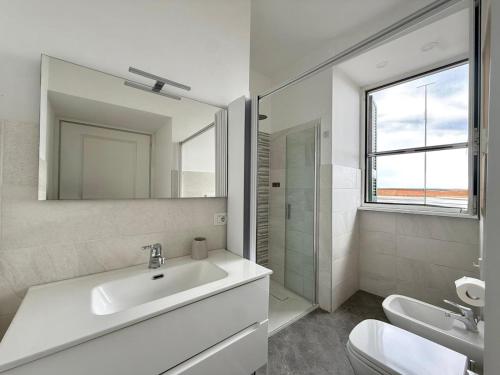 a white bathroom with a sink and a mirror at Suite Home in Naples