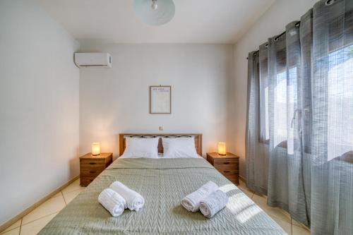 a bedroom with a bed with two towels on it at Viri Blue in Ágios Ioánnis