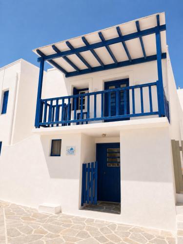 a white house with blue doors and a balcony at Cozy apartments Paros Kostos in Kóstos