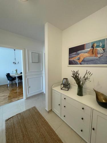 a living room with a dresser and a painting on the wall at Apartment Allure in Čapljina