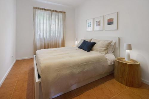 a white bedroom with a large bed and a table at Beach House - Mountain And Ocean in Porto Formoso