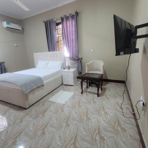 a bedroom with a bed and a flat screen tv at Mary homestays in Dar es Salaam