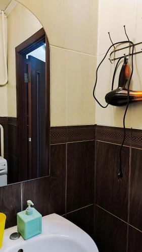 a bathroom with a mirror and a white sink at Водопійна 19 CityRooms in Bila Tserkva