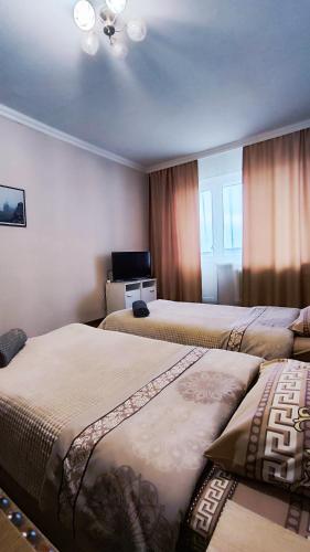 a hotel room with two beds and a television at Водопійна 19 CityRooms in Bila Tserkva