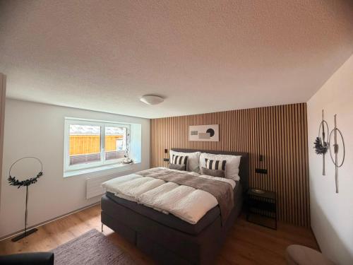 a bedroom with a large bed and a window at Apartment Enzian in Saas-Grund