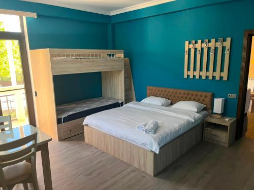 a bedroom with a bunk bed with a desk and a table sidx sidx at Khidikari Hotel in Ambrolauri