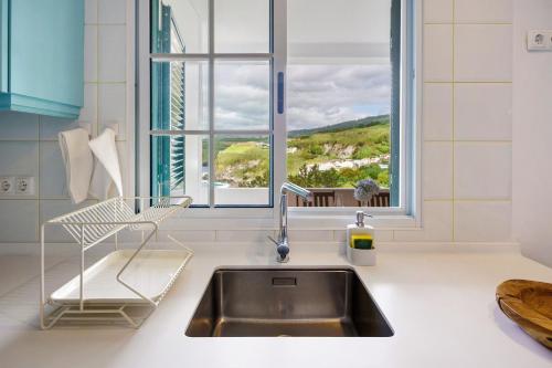 a kitchen counter with a sink and a window at Beach House - Mountain And Ocean in Porto Formoso