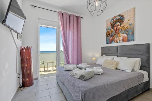 a bedroom with a large bed with a large window at S-EVA RESORT in Kolymbia