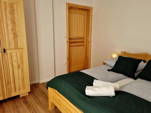 a bedroom with a bed with green and gray sheets at Zielony Zakontek in Ratułów