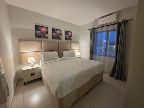 a bedroom with a large bed and two pictures on the wall at Galani Homes Comfort 2-Bed Suite in Gaborone