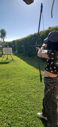 a woman holding a bow and arrow in a field at Villa Oliva Torotto in Niscemi