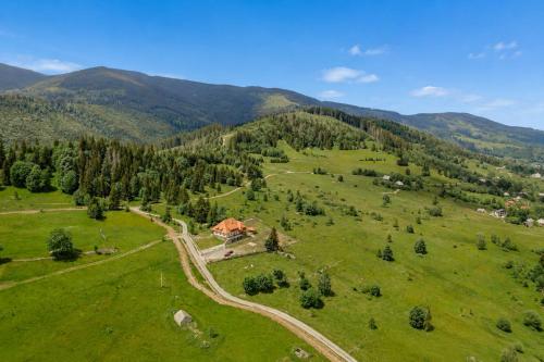 an aerial view of a green field with a house at ROGOChalet in Rogojel