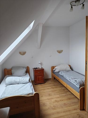 a room with two beds and a night stand in it at Kaszubska Enklawa in Rytel