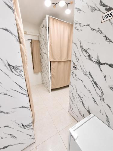 a bathroom with black and white marble walls at Best Inn Hostel and Café Patong Beach in Patong Beach