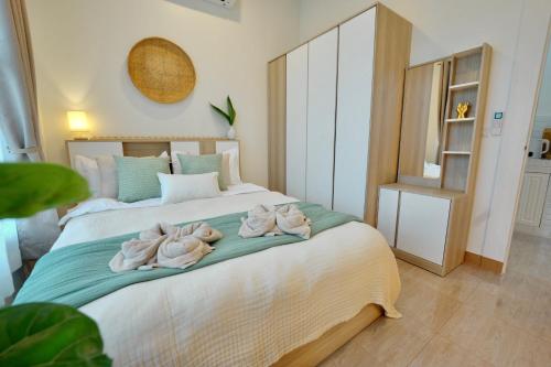 a bedroom with two swans towels on a bed at Chaloklum Beach House in Chaloklum