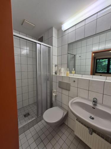 a bathroom with a shower and a toilet and a sink at RTB-Hotel - Sportschule in Bergisch Gladbach