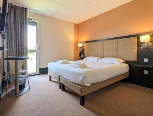 a bedroom with a large bed and a window at The Originals City, Hôtel La Verriaire, Cholet Sud in La Verrie