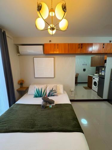 a bedroom with a large bed and a chandelier at At LBS 888 Condo Unit Rental-Full Relaxing Seaview 304-10Flr in Lapu Lapu City