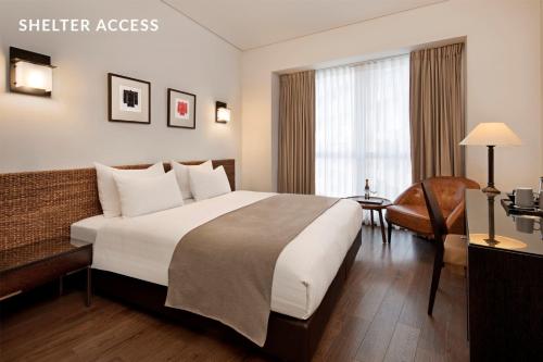a hotel room with a large bed and a desk at Vital - Urban boutique hotel TLV in Tel Aviv