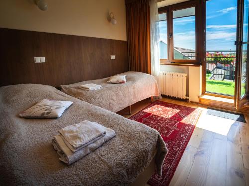 a room with two beds with towels on them at Apartament ALINA in Kartuzy