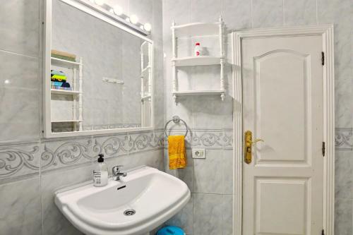 a white bathroom with a sink and a mirror at Beach 2-bedroom in Los Cristianos in Los Cristianos