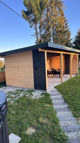 a building with a picnic table in a yard at La Știubei Cabin in Mărişel