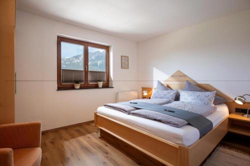 a bedroom with a large bed and a window at Ferienwohnung Tommarlhof in Söll