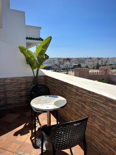 a table and chairs on a balcony with a view at Hôtel Majestic Rabat Centre in Rabat