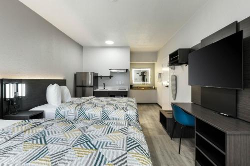 a hotel room with a bed and a kitchen at Studio 6 Suites Jacksonville, NC - Camp LeJeune in Jacksonville