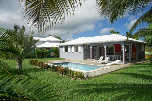 a house with a swimming pool in the yard at Villa Aquarium in Saint-François