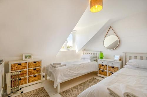 a white bedroom with two beds and a mirror at 4 Bed in Reydon oc-l30001 in Reydon