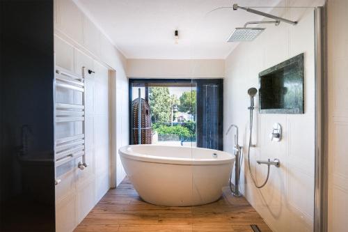 a white bath tub in a bathroom with a window at Sea View Villa in most upscale Yalikavak in Bodrum City