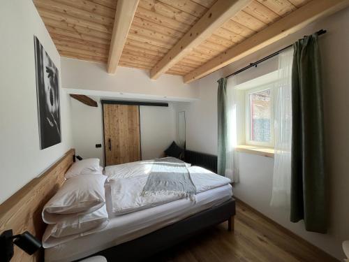 a bedroom with a bed and a window at Mas dal Vent in Valfloriana