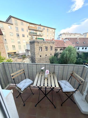 a wooden table and two chairs on a balcony at Stilvolles Apartment im Herzen von Krems in Krems an der Donau