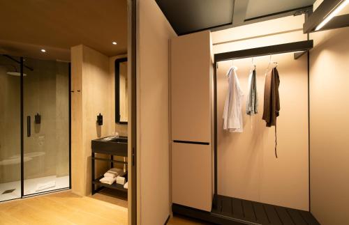 a bathroom with a walk in shower and a glass door at Breda Suites Hotel Milano in Milan