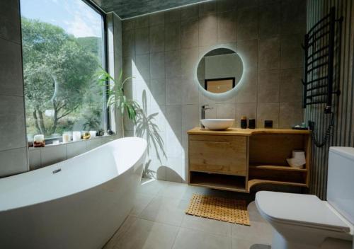 a bathroom with a tub and a sink and a mirror at "The Nest" Premium Mountain Lodge with Alpine retreat & Sauna in Vanadzor