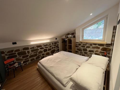 a bed in a room with a stone wall at Mas dal Vent in Valfloriana