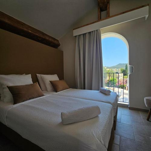 a bedroom with a large bed with a large window at Villa Onyra - Studios, Suites & Villa in Saint-Cyr-sur-Mer