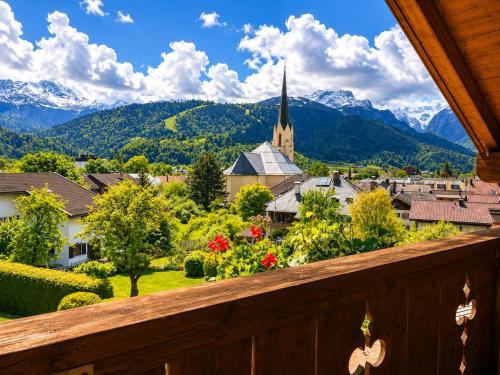 a view from a balcony of a small town with a church and mountains at Hotel Schatten in Garmisch-Partenkirchen