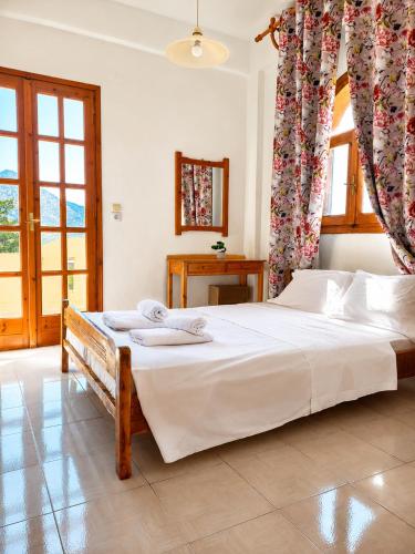 a bedroom with a large bed with white sheets at Genos suites in Stavros