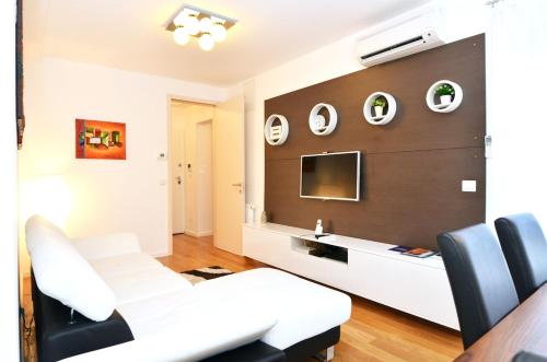 a living room with a white couch and a tv at Apartment Trnje in Zagreb